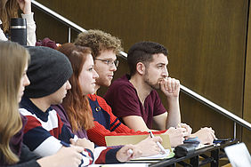 Studierende sitzen im Hörsaal und hören interessiert einer Vorlesung zu 