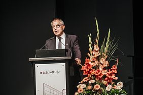 Mann spricht am Rednerpult bei der Graduiertenfeier der Hochschule Esslingen