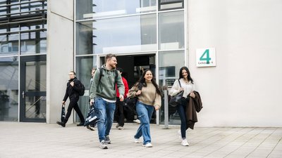 Studierende laufen aus der Hochschule raus