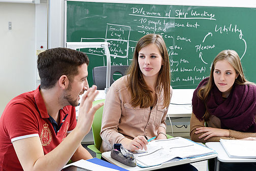 Studierenden diskutieren im Seminarraum