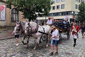 In einer Kutsche fahren der Rektor und seine Gäste mit.