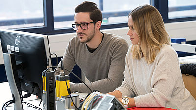 Zwei Studenten arbeiten zusammen am PC im Labor 