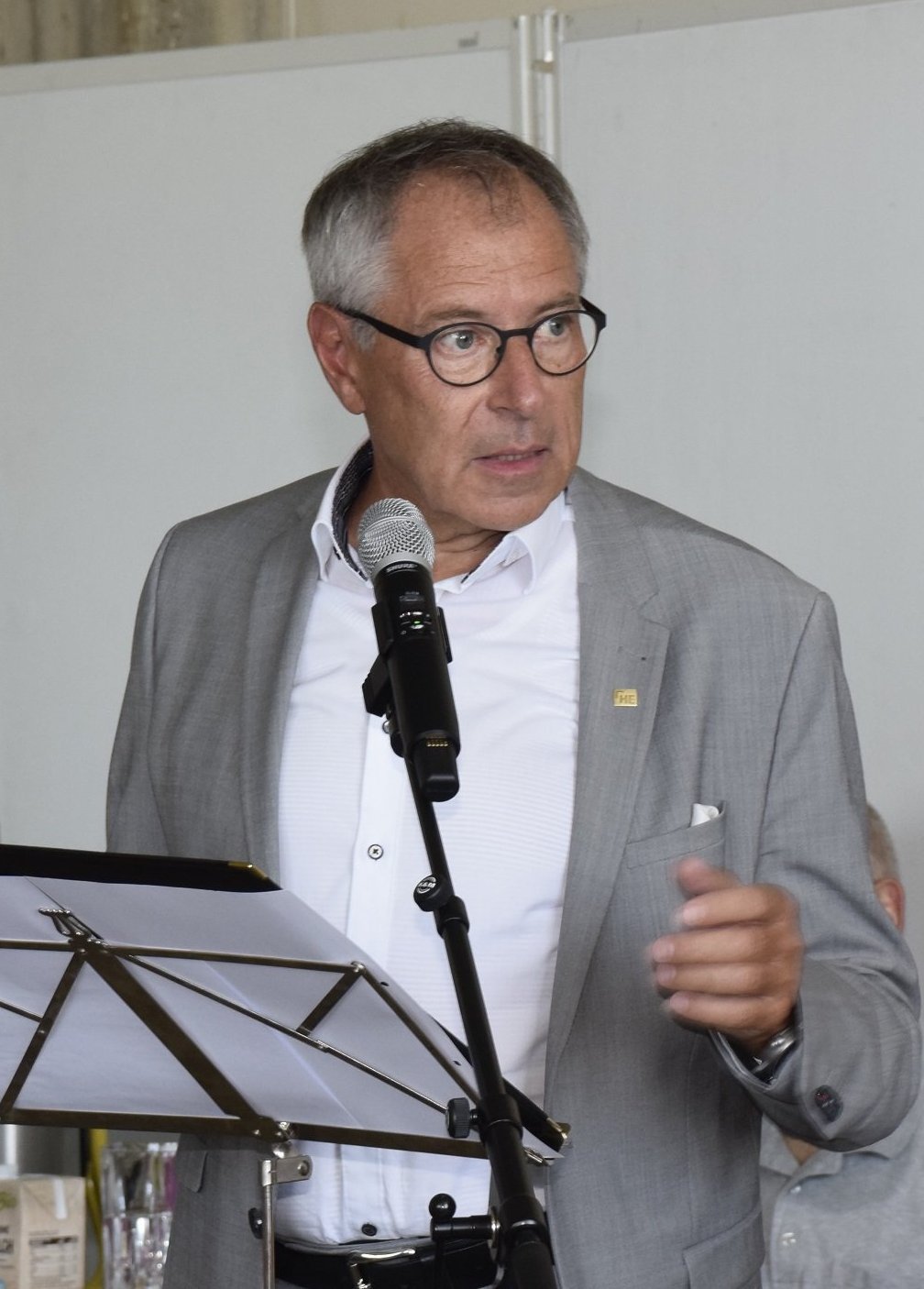 Ein Mann steht an einem Mikro und spricht