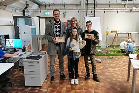 Familie steht in der Kreativwerkstatt der Hochschule Esslingen