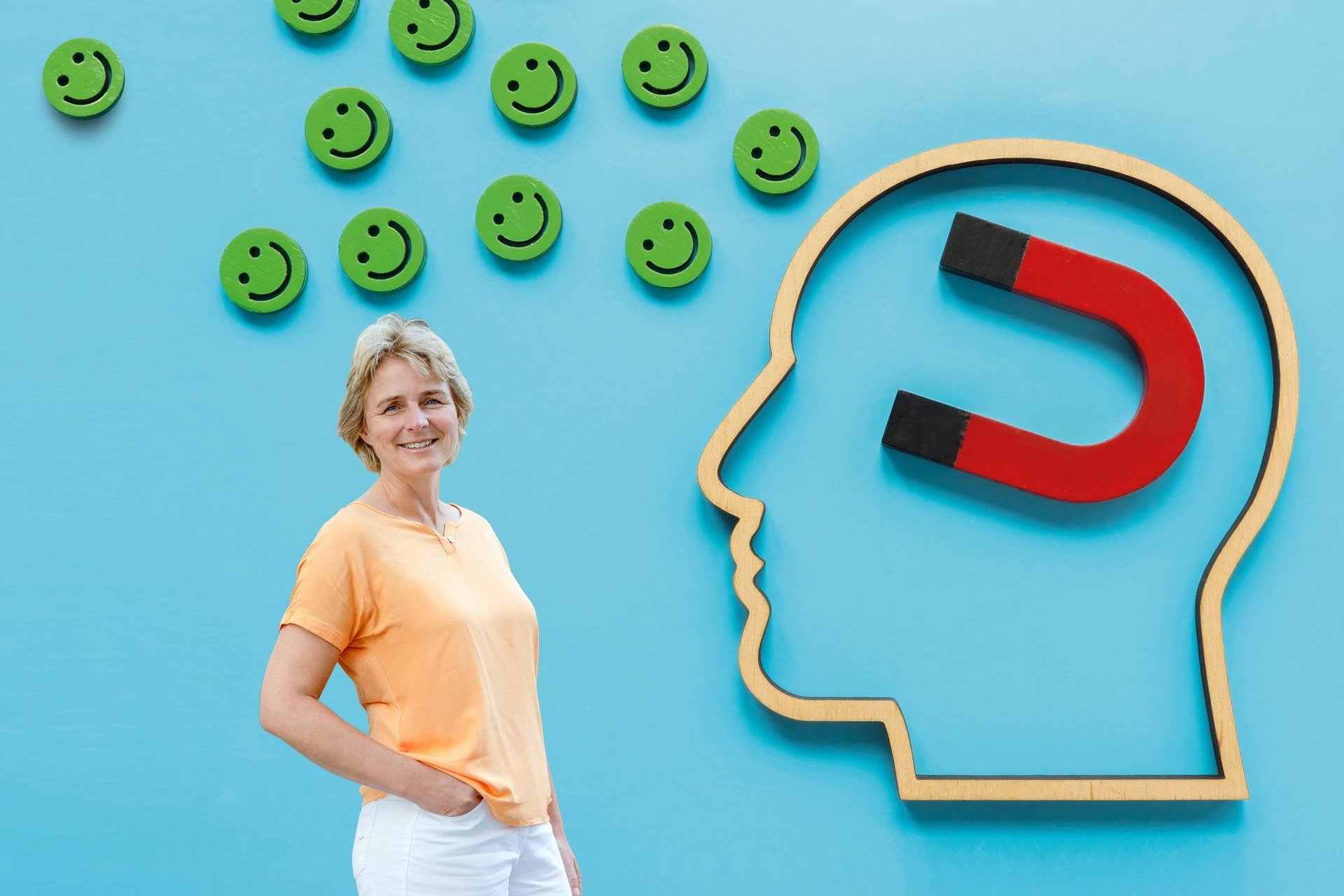 Frau vor blauem Hintergrund mit Smileys