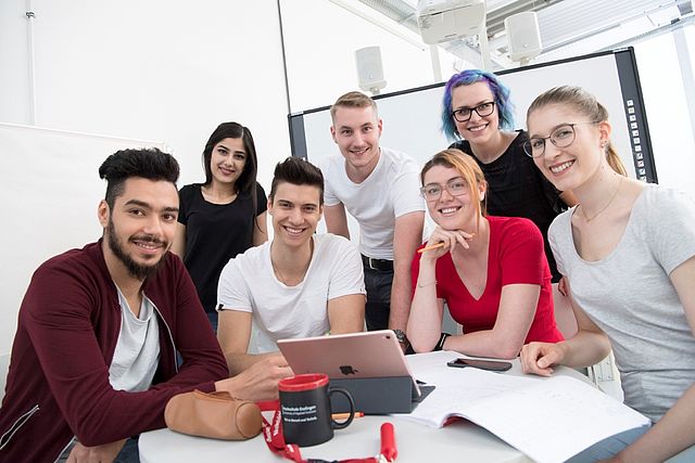 Gruppe von Studierenden sitzt um einen Arbeitstisch