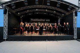 Ein Chor steht auf einer Bühne und singt