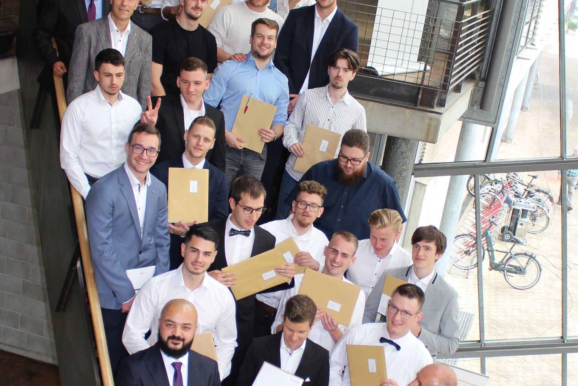 Studierende nach der Zeugnisübergabe auf der Treppe an der HS Esslingen