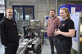 Zwei Männer und eine Frau mit Rennauto der Hochschule Esslingen