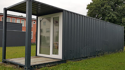 Ein Frachtcontainer von außen, der in ein Minihaus umegbaut worden ist. 