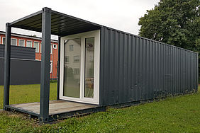 Ein Frachtcontainer von außen, der in ein Minihaus umegbaut worden ist. 