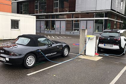 Elektrifizierter BMW Z3 und BMW i3 an der Ladesäule auf dem Parkplatz City Campus Hochschule Esslingen. Bild: Fakultät Mobilität und Technik