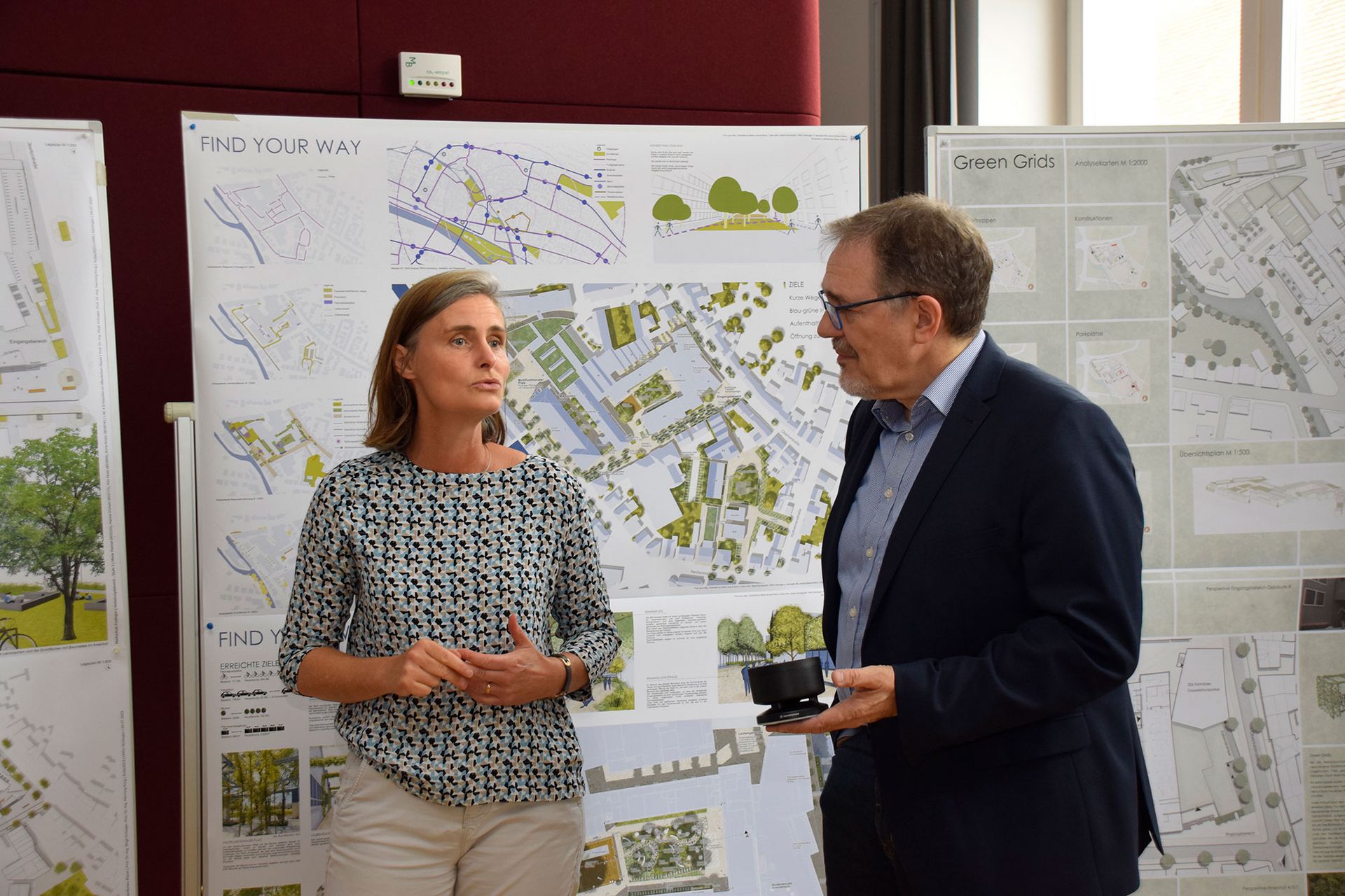 Prof. Dr. Birgit Kröniger und Prorektor Prof. Dr. Maruks Tritschler im Gespräch über die Entwürfe des Gestaltungswettbewerbs.