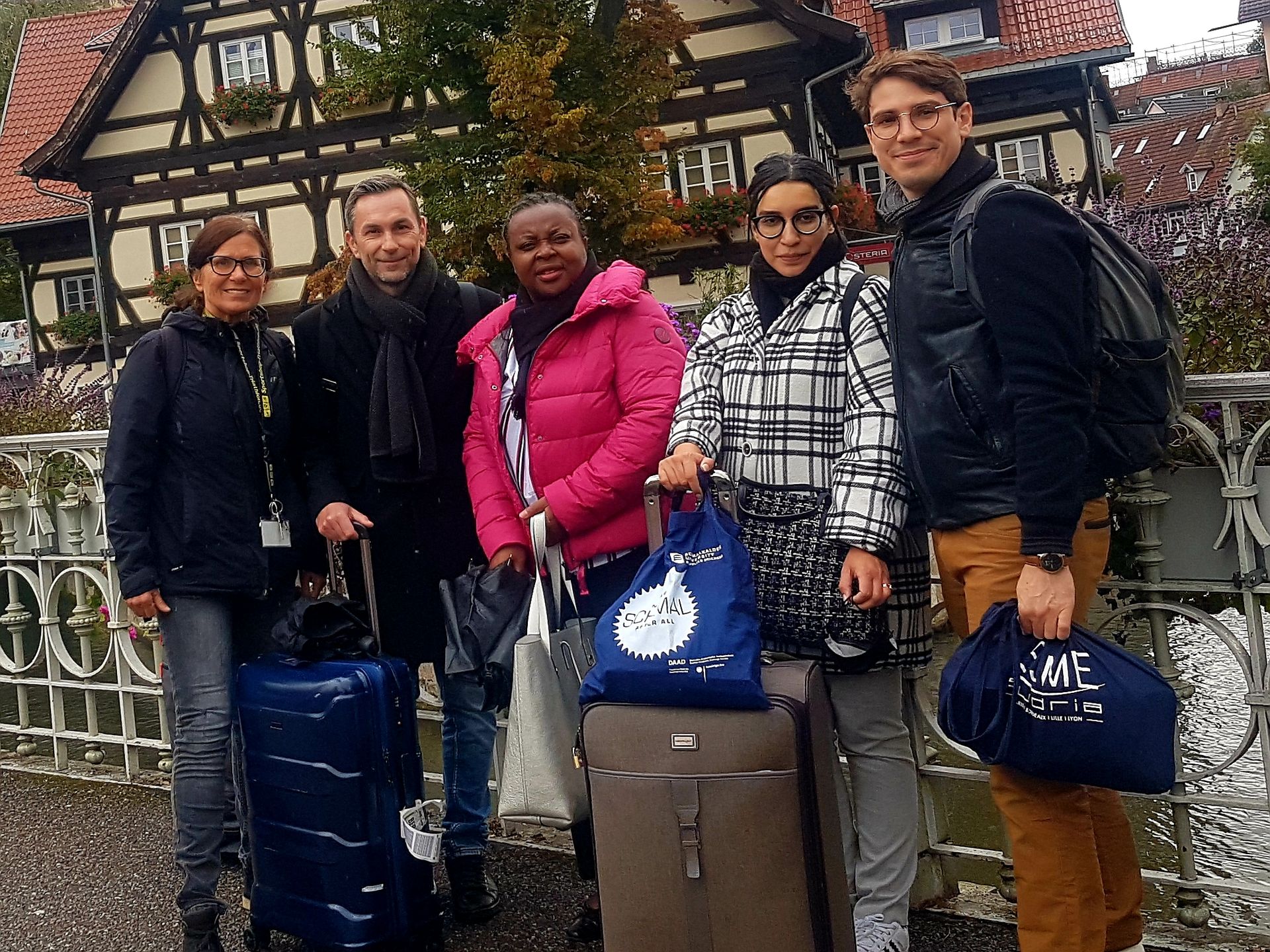 Fünf Personen, weiblich und männlich, stehen nebeneinander und blicken in die Kamera