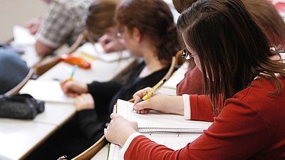 Schreibende Studierende in der Vorlesung- Sicht von links hinten