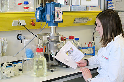 Student stands in the laboratory and reads instructions 