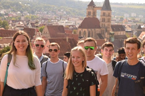Group of international students, male and female, with city in the background 