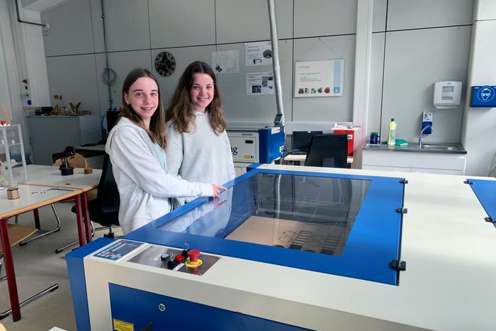 Zwei M&auml;dchen betrachten den Lasercutter beim Girls Day in G&ouml;ppingen.