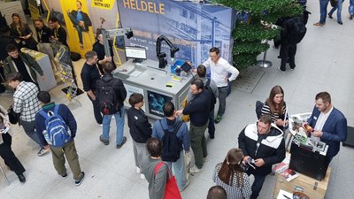 Menschen in einem Ausstellungsraum mit Ständen