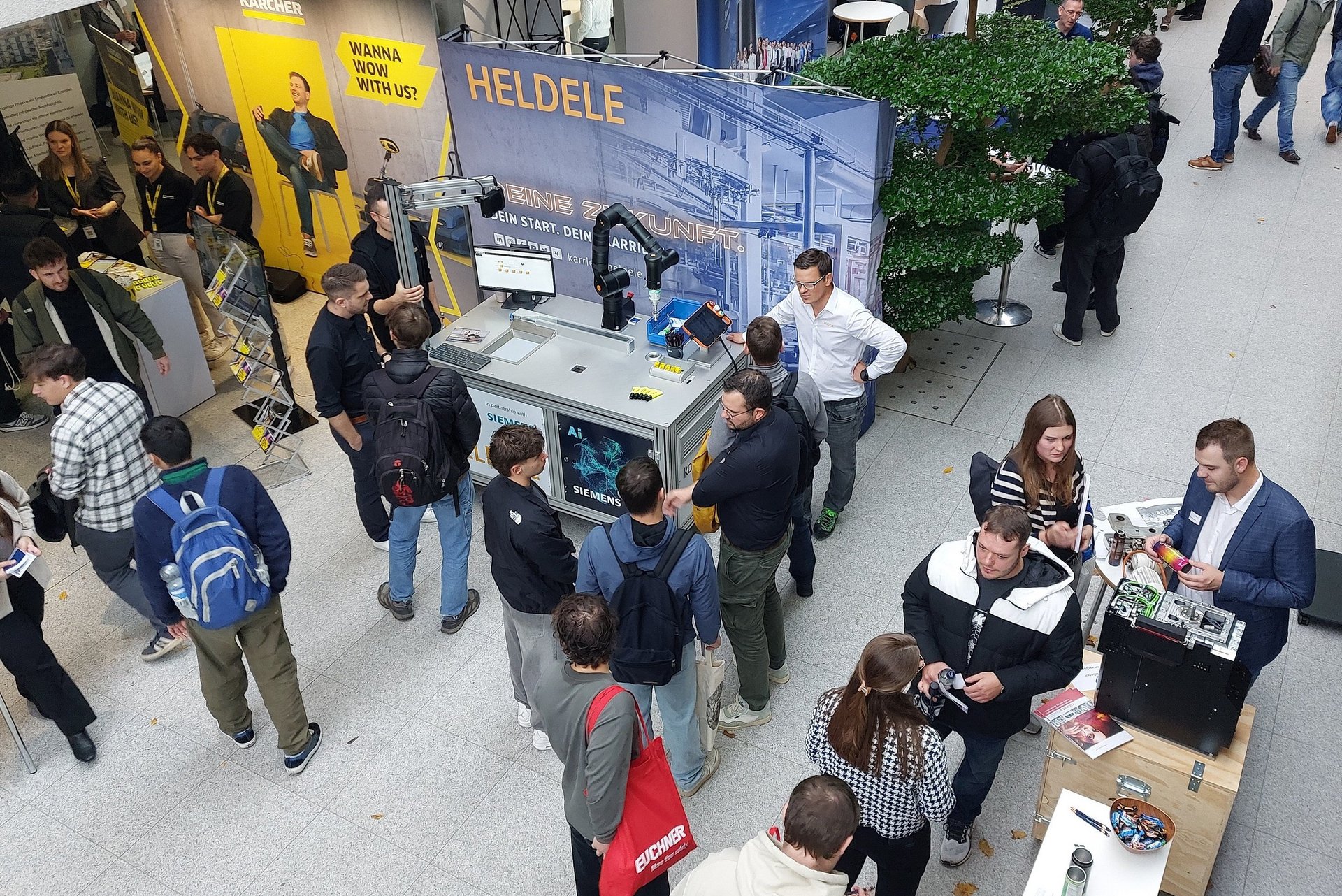 Menschen in einem Ausstellungsraum mit Ständen