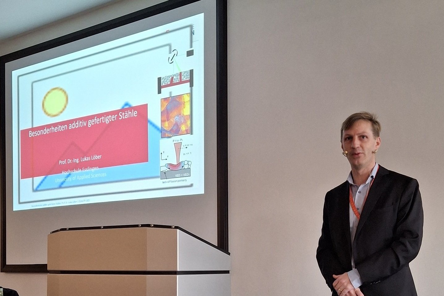 Redner steht vorne - im Hintergrund Präsentation