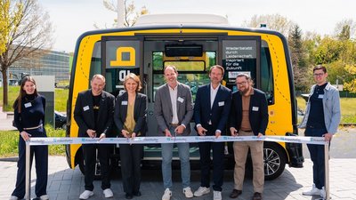 Gruppe von M&auml;nnern und Frauen schneidet ein rotes Band durch