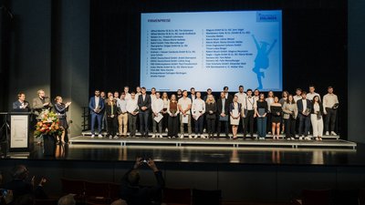 Viele Preistr&auml;gerinnen und Preistr&auml;ger stehen auf der B&uuml;hne bei der Graduiertenfeier