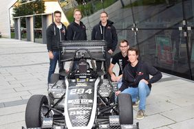 Studierende stehen um einen Rennwagen