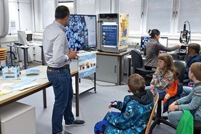 Ein Professor mit Kindern im Labor Mikroskopie