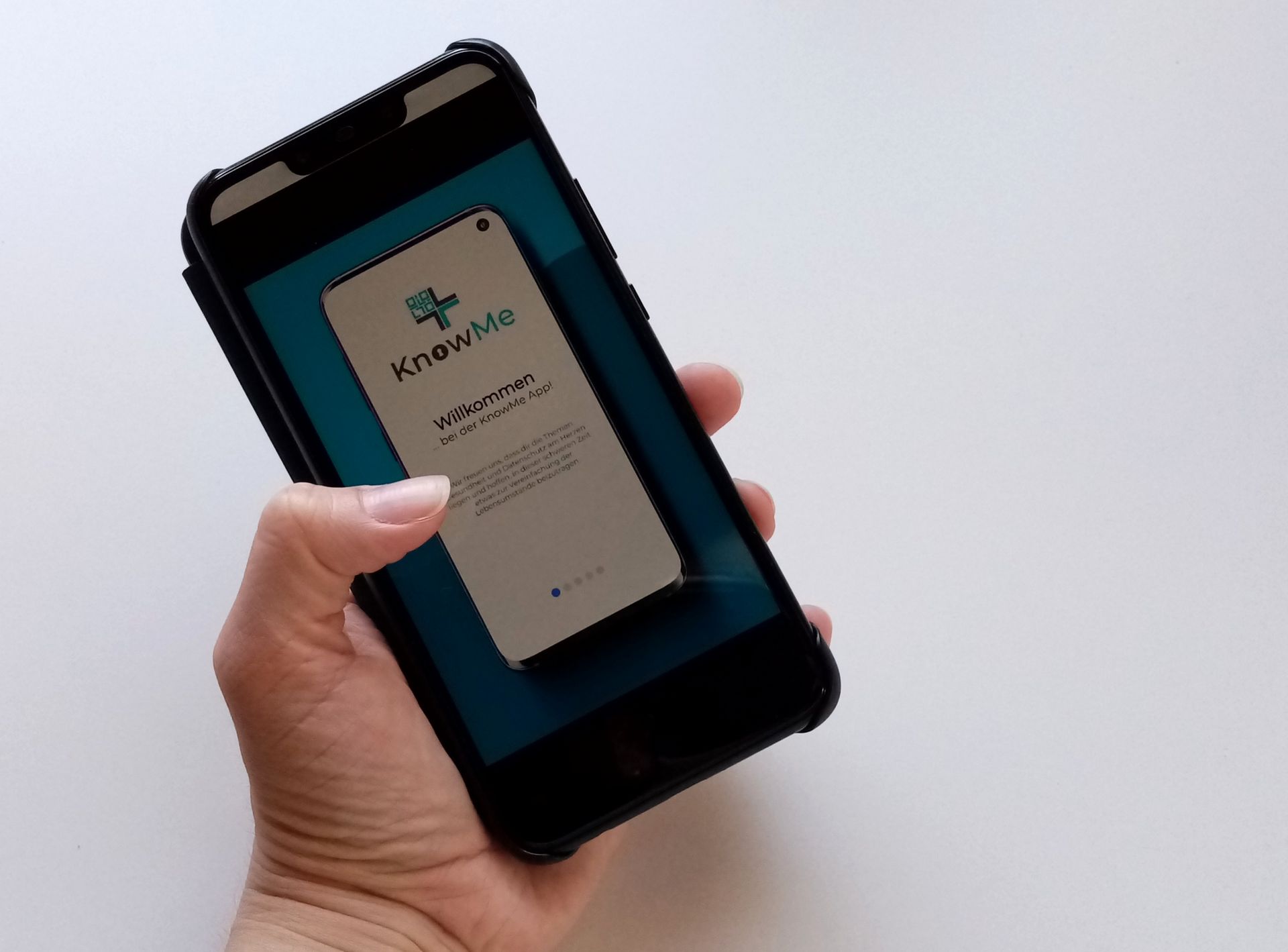 Eine Hand hält ein Handy auf dem eine App angezeigt wird. 