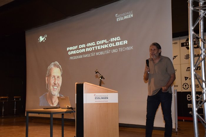 Mann h&auml;lt eine Ansprache in der Aula
