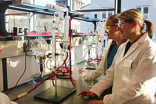 Two female students in front of a test facility 