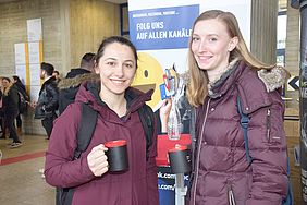 Zwei Frauen mit Kaffeetasse in der Hand