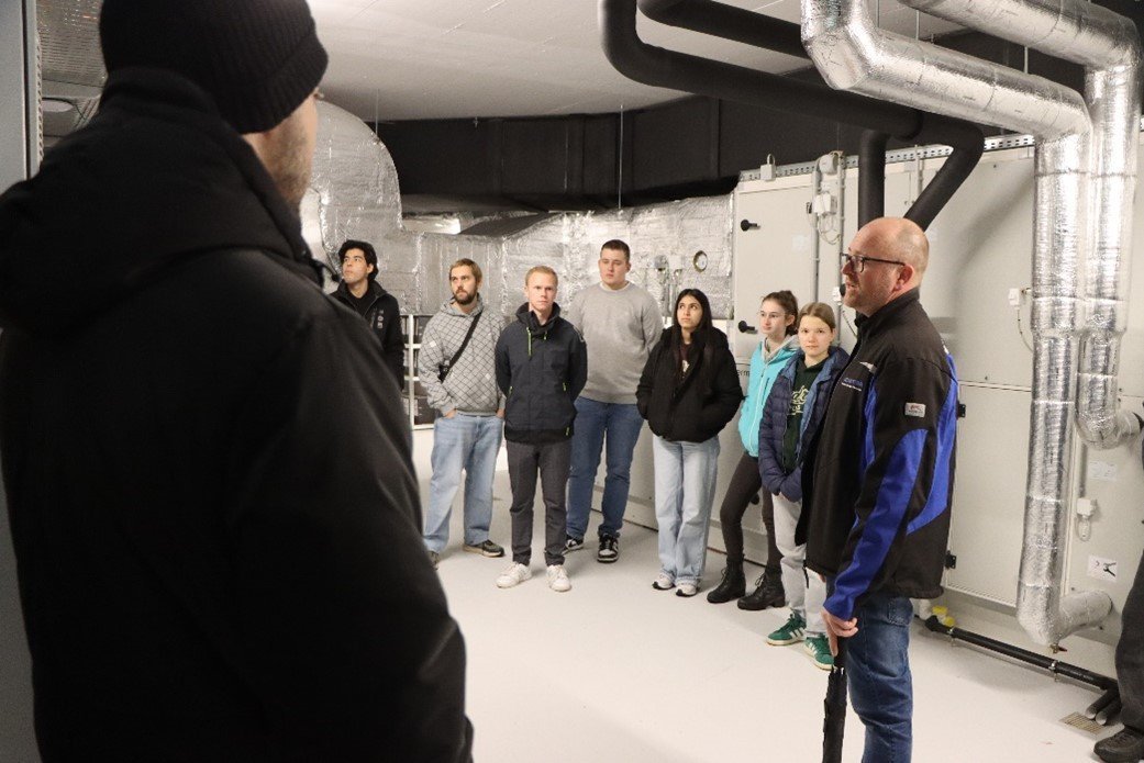 Menschen in einem Raum mit Rohren