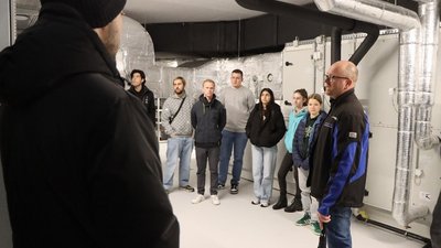 Menschen in einem Raum mit Rohren