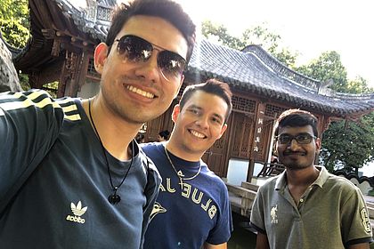 Drei internationale Studenten im chinesischen Garten