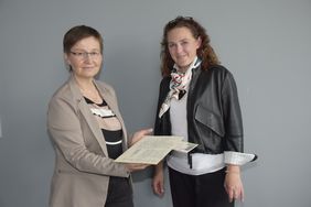 Zwei Frauen halten ein historisches Dokument in der Hand