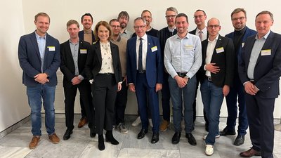 Mehrere M&auml;nner und eine Frau stehen zum Gruppenfoto zusammen