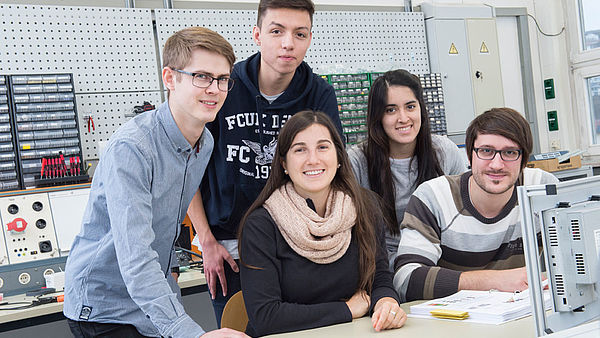 Gruppe von Studierenden vor einem Schaltkasten