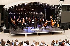 Das Orchester der Hochschule Esslingen in Großaufnahme auf der Bühne beim Mercedes-Benz Museum.