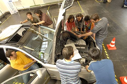 Studierende arbeiten an einem Fahrzeug