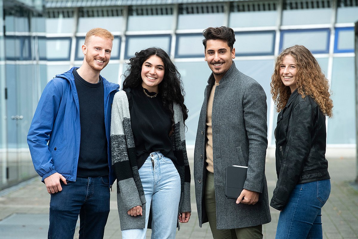 Eine Gruppe Studierende steht auf dem Campus Stadtmitte.