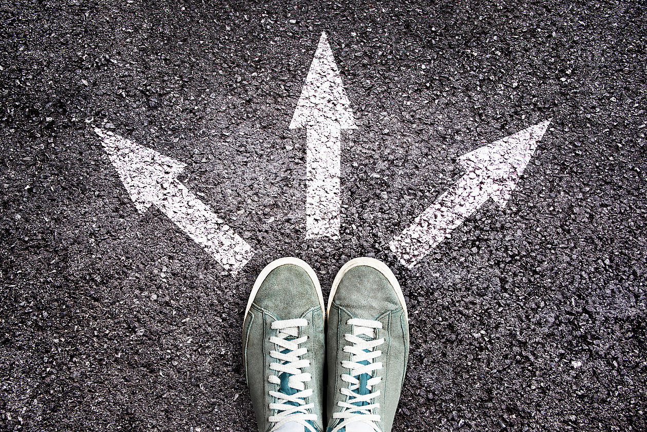 Schuhe und Pfeile auf Asphalt zeigen in unterschiedliche Richtungen Schuhe und Pfeile auf Asphalt zeigen in unterschiedliche Richtungen