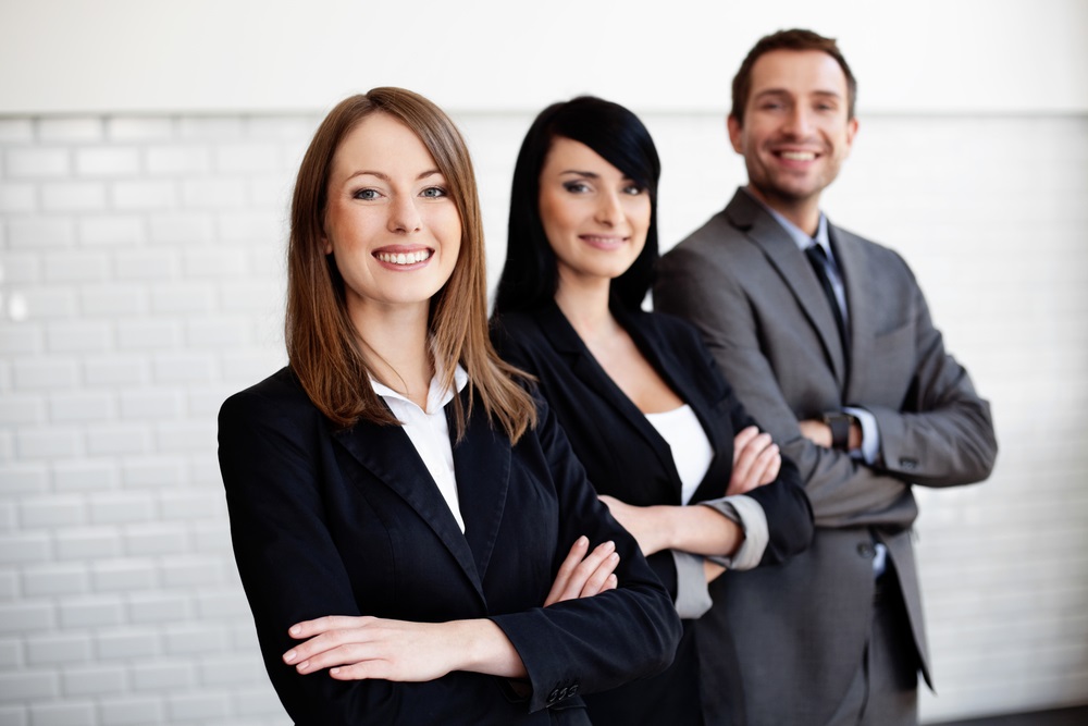 Zwei Frauen und ein Mann im Business-Outfit