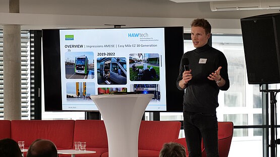 Mann steht vor Publikum und spricht bei einer HAWtech-Tagung