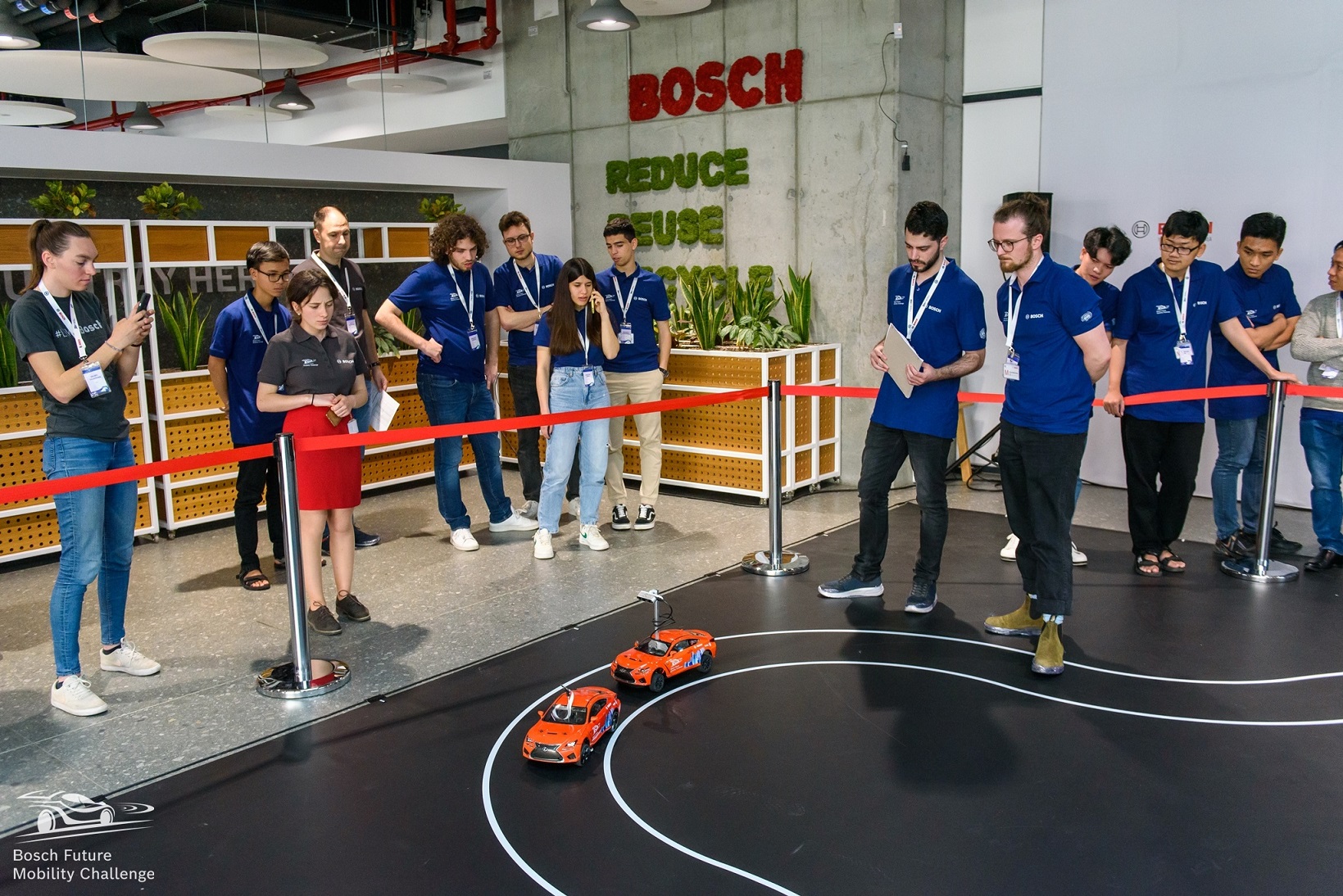 Verschiedene Teilnehmende an einem Wettbewerb mit autonom fahrenden kleinen Autos