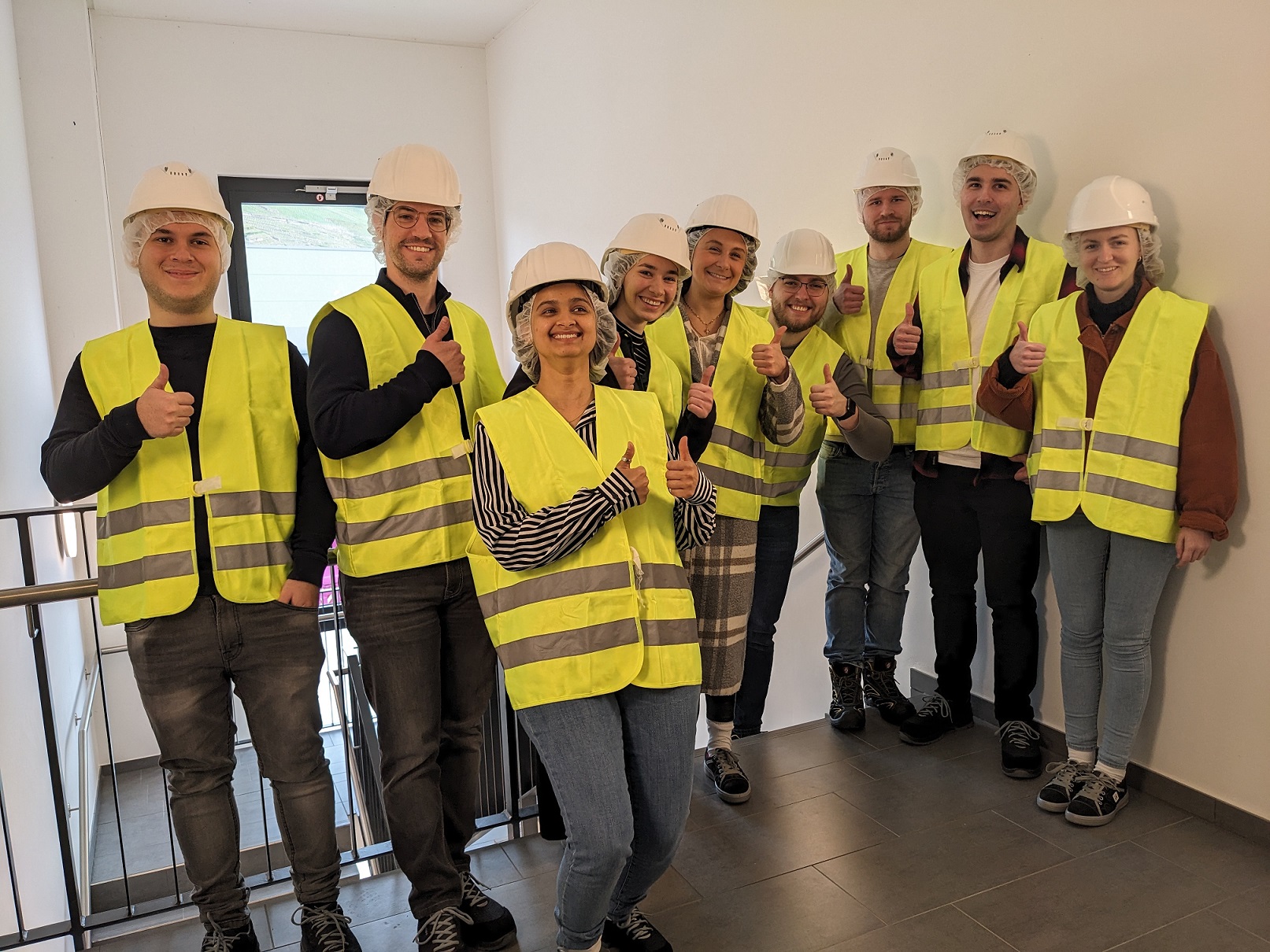 Gruppe von Studierenden mit Warnwesten und Helmen