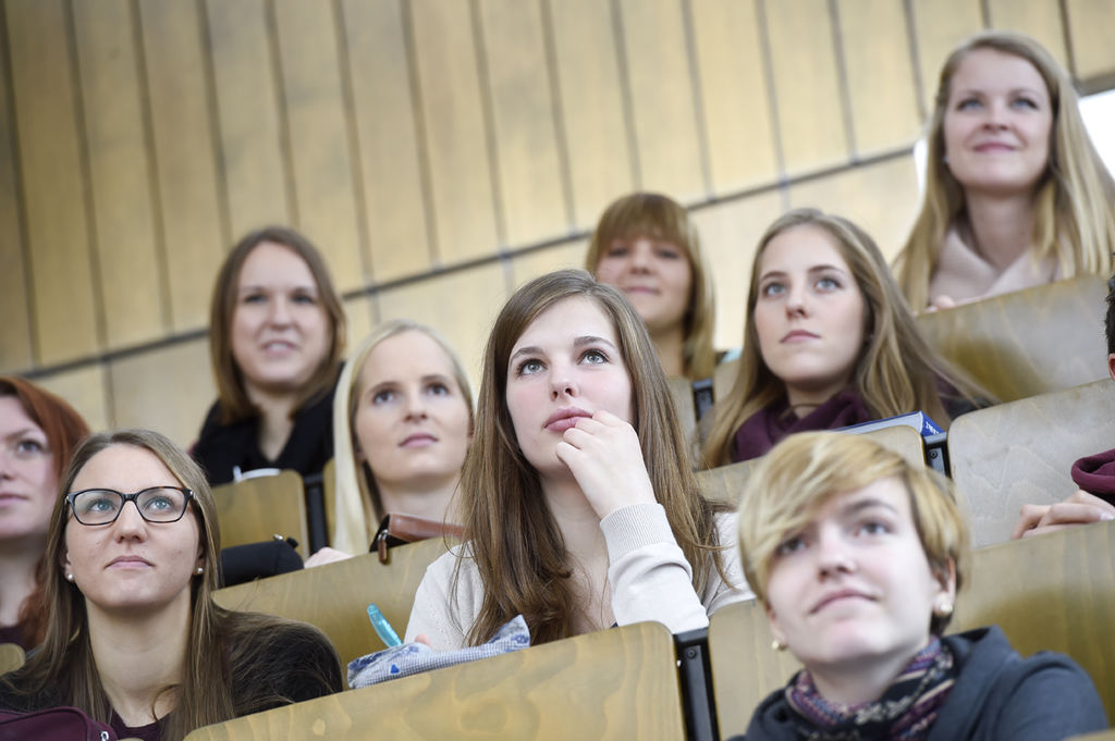 mehrere Studierende im Hörsaal von vorne beim Zuhören einer Vorlesung