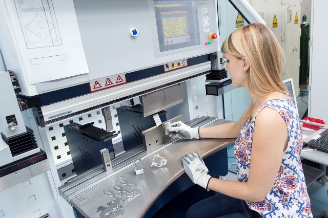 Studentin an einer Maschine im Labor Maschinenbau