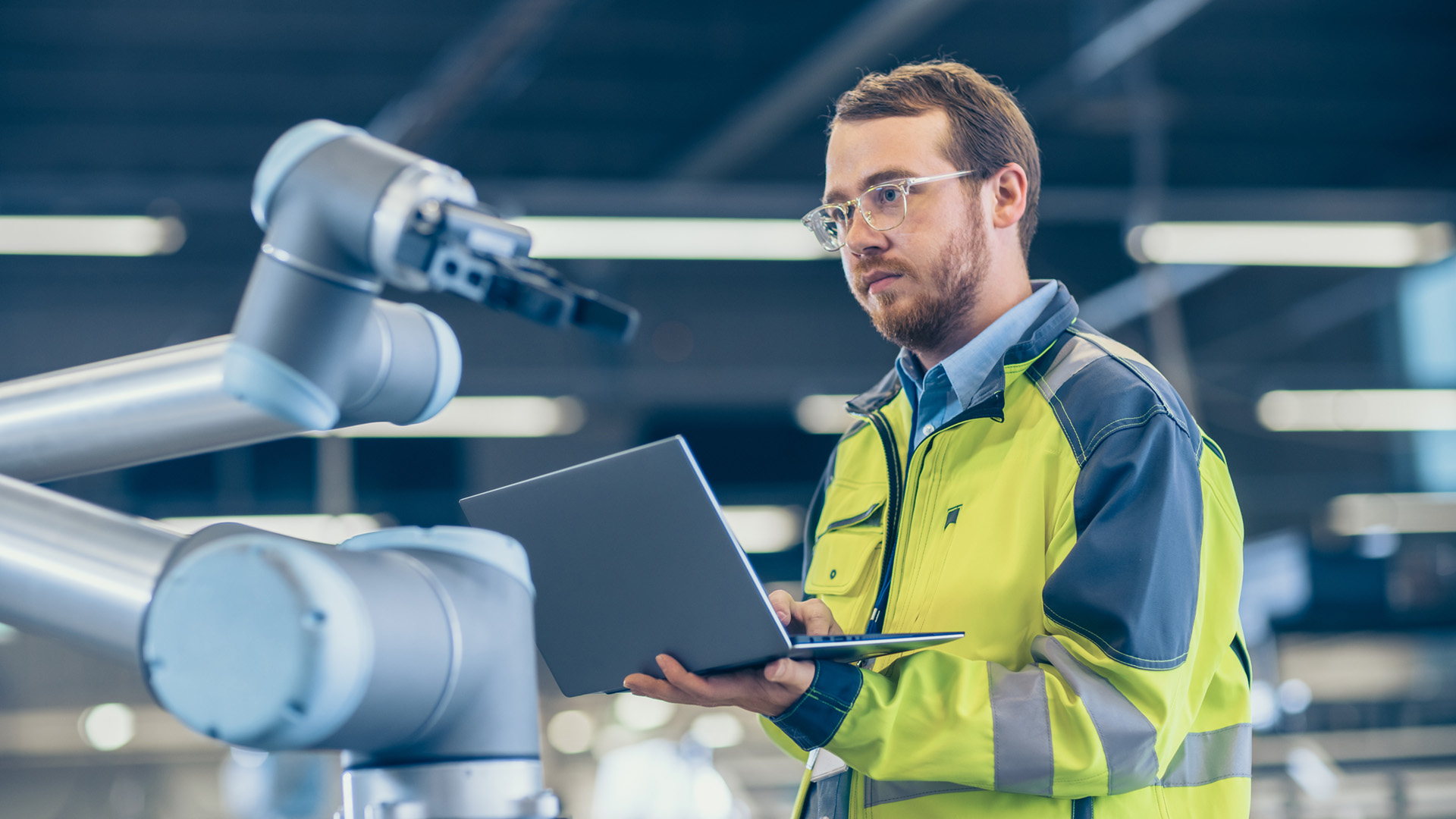 Elektroingenieur bei Versuch mit Roboterarm